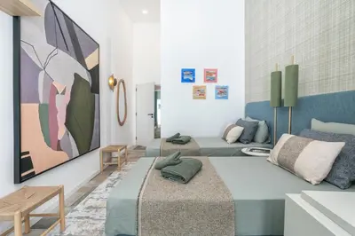 a room with three beds and a painting on the wall at Casa Bella in Faro