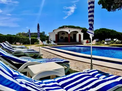 a group of lounge chairs next to a swimming pool at Villa SOLAR DO MONTE 6 in Albufeira