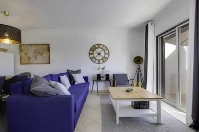 a living room with a blue couch and a table at CLUB ALBUFEIRA - 2 bedroom apartment, air conditioning and pools in Albufeira