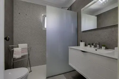 a bathroom with a white sink and a toilet at CLUB ALBUFEIRA - 2 bedroom apartment, air conditioning and pools in Albufeira