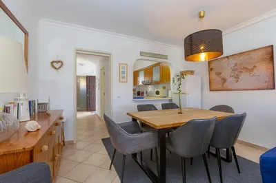 a dining room and living room with a table and chairs at CLUB ALBUFEIRA - 2 bedroom apartment, air conditioning and pools in Albufeira