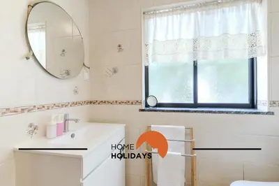 a bathroom with a sink and a mirror and a window at #321 Lageado 1S by Home Holidays in Vale de Pedras