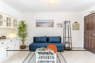 a living room with a blue couch in a kitchen at #321 Lageado 1S by Home Holidays in Vale de Pedras