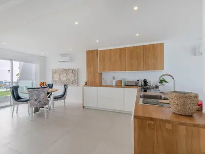 a kitchen with wooden cabinets and a table with chairs at Holiday Home Nannoush - Vip Properties by Interhome in Albufeira