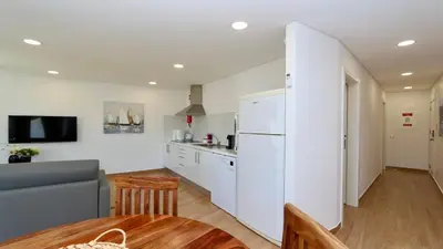 a kitchen with a white refrigerator and a kitchen table at Tenis Golf Mar A209 - CD 309 - Sleeps 2 adults and 2 children in Vilamoura