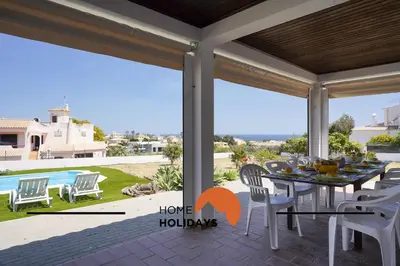 a dining room with a table and chairs on a patio at #331 Casa Chico Rita by Home Holidays in Sesmarias