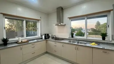 a kitchen with a sink and two windows at Figo by Check-in Portugal in Quarteira