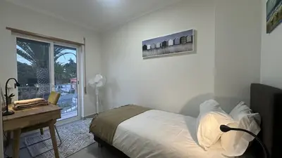 a bedroom with a bed and a desk and a window at Figo by Check-in Portugal in Quarteira