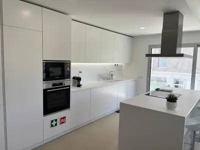 a kitchen with white cabinets and a stove top oven at Casa Verde in Albufeira