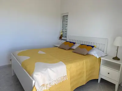a bedroom with a large bed with a yellow blanket at Solar dos Lirios in Loulé