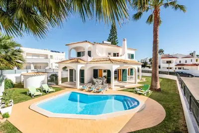 a villa with a swimming pool in front of a house at Villa Julia Gale in Guia