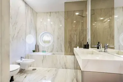 a bathroom with a sink and a tub and a toilet at Villa Melvin in Quarteira