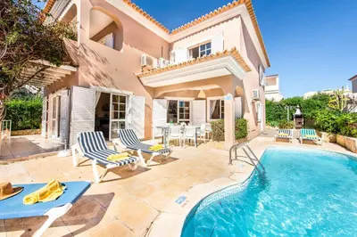 a villa with a swimming pool and a house at Villa Casanova Golf in Quarteira