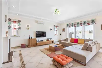 a living room with a couch and a tv at Villa Sunflower in Albufeira