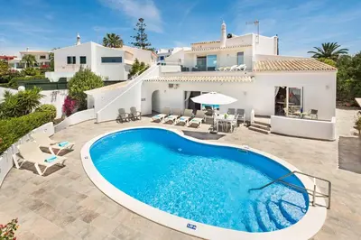 a villa with a swimming pool in front of a house at Villa Barbara in Albufeira