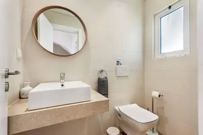 a bathroom with a sink and a toilet and a mirror at Villa Barbara in Albufeira
