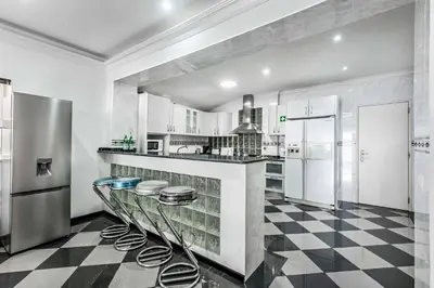 a kitchen with a black and white checkered floor at Villa Mogan in Albufeira