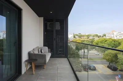 a balcony with a chair and a view of a street at Terracos de Quarteira II Caribe by Real Properties in Quarteira