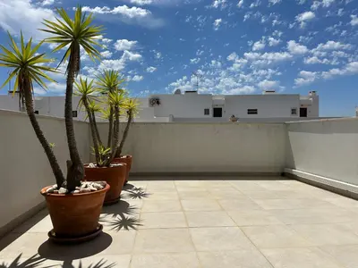 a balcony with palm trees and a building at Monte da Vinha By FHR in Quarteira