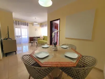 a dining table and chairs in a living room at Sun House in Albufeira