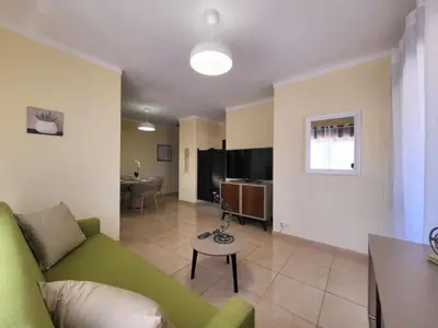 a living room with a green couch and a table at Sun House in Albufeira