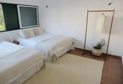a room with two beds and a window at Manso da Falésia in Olhos de Água