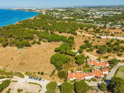 an aerial view of an island with houses and the ocean at Manso da Falésia in Olhos de Água