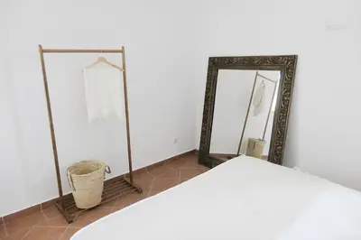 three mirrors in a room with a bed and a basket at Manso da Falésia in Olhos de Água
