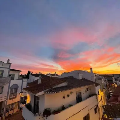 a sunset over a city with buildings and roofs at Albufeira Baixa Apartment in Albufeira