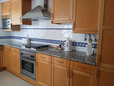 a kitchen with wooden cabinets and a stove top oven at Albufeira Baixa Apartment in Albufeira