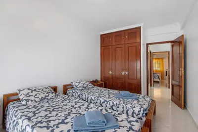 a bedroom with two beds and a closet at Excellent Apartment in Olhos D´Água in Olhos de Água