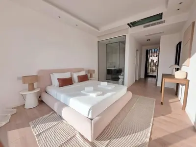 a white bedroom with a large bed and a living room at Villa São Rafael in Albufeira