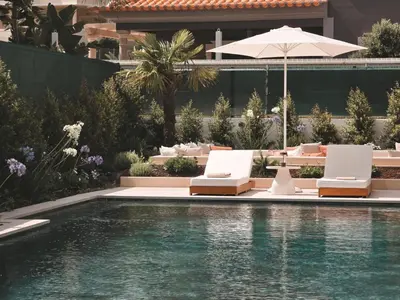 a swimming pool with lounge chairs and an umbrella at Villa São Rafael in Albufeira