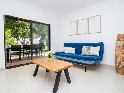 a living room with a blue couch and a table at Vila Paço no Vale by Stay ici Algarve Holiday Rental in Albufeira