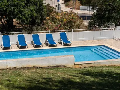 a group of chairs sitting in a swimming pool at Vila Paço no Vale by Stay ici Algarve Holiday Rental in Albufeira
