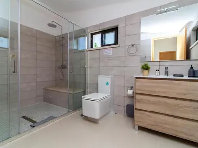 a bathroom with a shower and a toilet and a sink at Vila Paço no Vale by Stay ici Algarve Holiday Rental in Albufeira