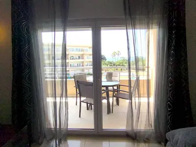 a room with a balcony with a table and chairs at Barracuda dom in Albufeira