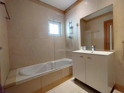 a bathroom with a bath tub and a sink and a bath tub at Barracuda dom in Albufeira