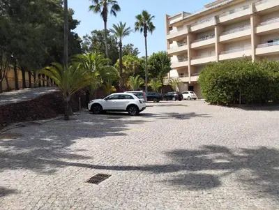 a white car parked in a parking lot next to a building at Barracuda dom in Albufeira