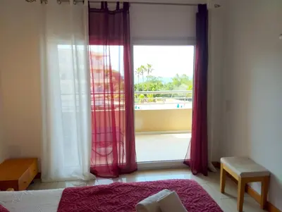 a bedroom with a window with a view of a balcony at Barracuda dom in Albufeira