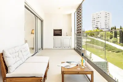 a living room with a couch and a table on a balcony at Modern 1-Bed Apartment with Terrace Albufeira in Albufeira