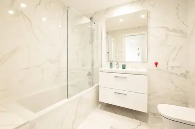 a white bathroom with a shower and a sink at Modern 1-Bed Apartment with Terrace Albufeira in Albufeira