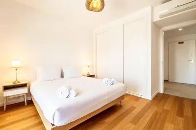 a bedroom with a white bed with towels on it at Modern 1-Bed Apartment with Terrace Albufeira in Albufeira