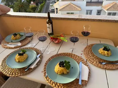 a table with plates of food and glasses of wine at Blue Wave Albufeira in Albufeira