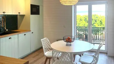 a kitchen with a table and chairs and a balcony at Blue Wave Albufeira in Albufeira