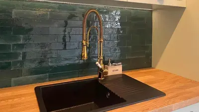 a kitchen sink with a bronze faucet on a counter at Blue Wave Albufeira in Albufeira