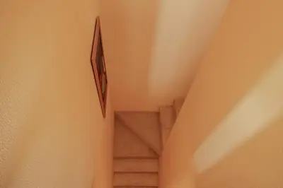 a staircase in a building with a picture on the wall at FLH Quinta do Lago Retreat with Terrace & Pool in Almancil