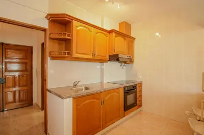 a kitchen with wooden cabinets and a sink at FLH Quarteira Seaview in Quarteira