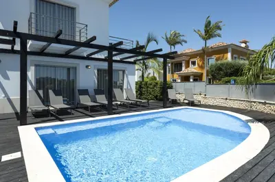 a swimming pool with chairs and a house at Villa da Ria - by HD Properties in Monte Negro