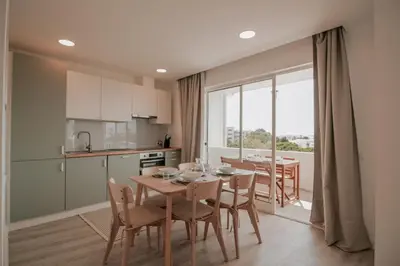 a kitchen and dining room with a table and chairs at FLH Albufeira Boho Chic with Balcony in Albufeira